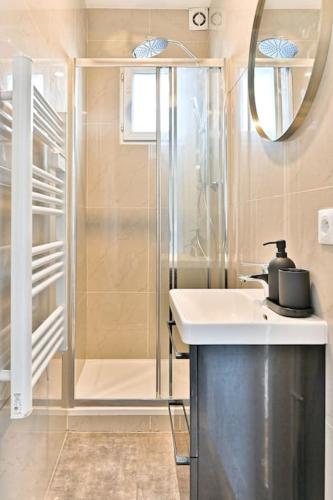une salle de bain avec un lavabo et une douche dans l'établissement Appartement Vue sur Tour effeil Defense, à Puteaux