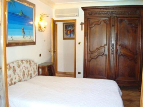 une chambre avec un lit et une armoire en bois dans l'établissement VILLA Les Oliviers, à Figanières