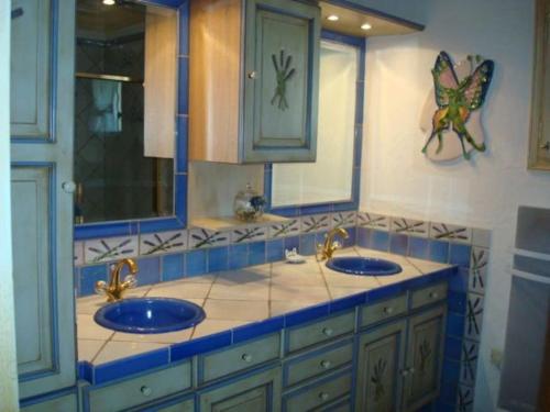 une salle de bain avec deux lavabos et un papillon sur le mur dans l'établissement VILLA Les Oliviers, à Figanières