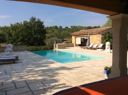 - une piscine avec une terrasse et une maison dans l'établissement VILLA Les Oliviers, à Figanières