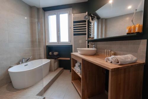 une salle de bain avec une baignoire blanche et un lavabo dans l'établissement Chic et spacieux 6 personnes- cite de la science, à Paris