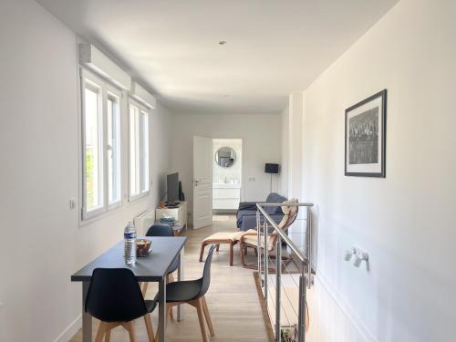 un salon blanc avec une table et des chaises dans l'établissement Superbe Maison Loft 80 m2 au calme avec jardin et parking privés proche Paris Disney la vallée village, à Fontenay-sous-Bois