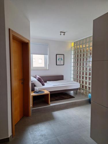 a bedroom with a bed and a table and a window at House Novalia in Novalja