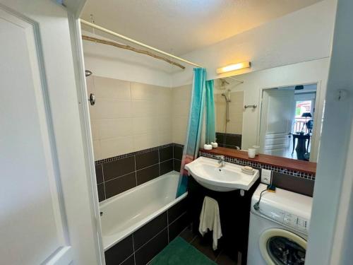 une salle de bain avec un lavabo et une baignoire dans l'établissement Grand appartement - Piscine - plage- Terrasse, à Saint-Jean-de-Luz