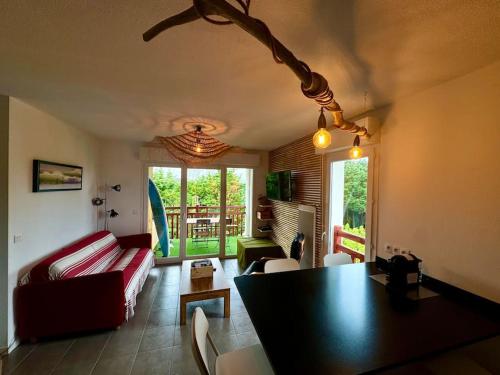 un salon avec un canapé rouge et une table dans l'établissement Grand appartement - Piscine - plage- Terrasse, à Saint-Jean-de-Luz