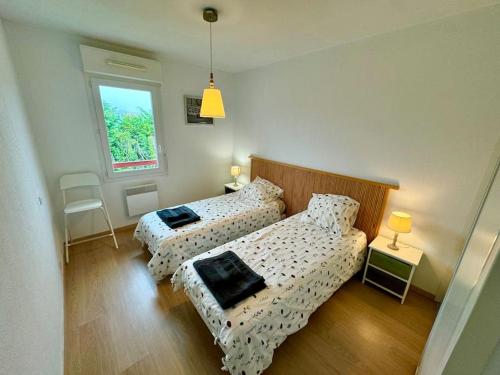 une chambre avec deux lits et un canapé dans l'établissement Grand appartement - Piscine - plage- Terrasse, à Saint-Jean-de-Luz