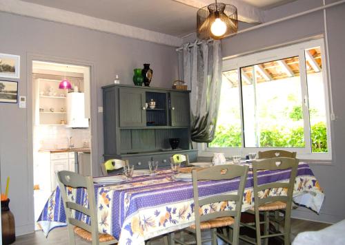 a kitchen with a table with chairs and a window at Gîte l'ancienne épicerie Meyronne in Meyronne