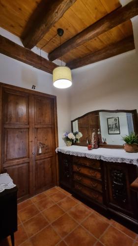 a room with a vanity with a mirror and wooden ceilings at Casa Tropiet in Beceite