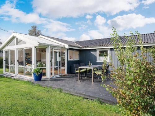 a house with a deck with a table at Holiday Home Leani - 200m from the sea by Interhome in Stubbekøbing