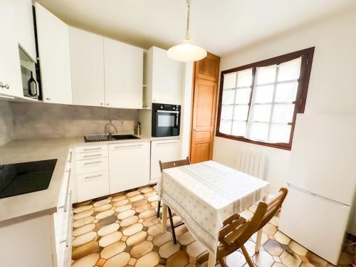 une cuisine avec une table et des chaises dans une cuisine dans l'établissement Anh Dao-Disneyland-Parking Gratuite et Terrasse, à Champs-sur-Marne