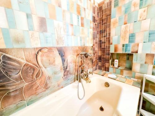 a bathroom with a bath tub with a bird painted on the wall at Anh Dao-Disneyland-Parking Gratuite et Terrasse in Champs-Sur-Marne
