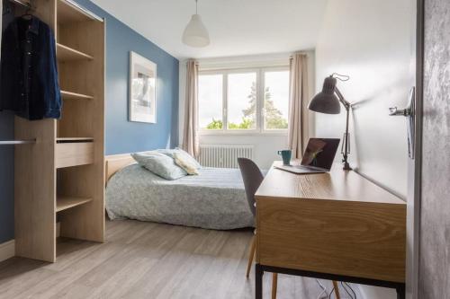 une chambre avec un lit et un bureau avec un ordinateur portable dans l'établissement Bambou YourHostHelper, à Hérouville-Saint-Clair
