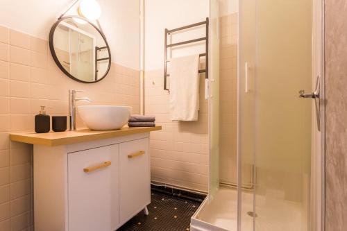 une salle de bain avec un lavabo et une douche dans l'établissement Bambou YourHostHelper, à Hérouville-Saint-Clair