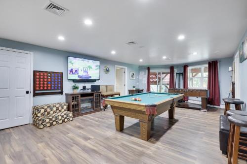ein Wohnzimmer mit einem Billardtisch und einem TV in der Unterkunft Cozy cottage in the heart of pocono in Long Pond