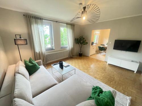 a living room with a white couch and a tv at APARTMENT KLAGENFURT Villa Frank No1 - with Free Parking, Air Conditioning, Smart-TV & Self Check-in in Klagenfurt