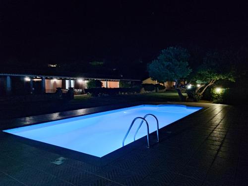 a swimming pool lit up at night at Abba Sixty - View, Pool & Parking - 200mt Sea in Tertenìa