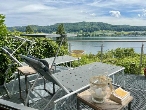 a table and chair on a balcony with a view of the water at Holiday Home Seepanorama by Interhome in Wangen