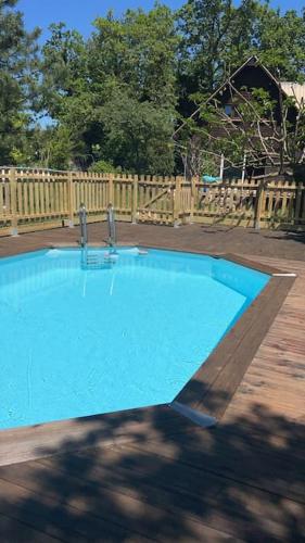 - une piscine bleue dans une cour avec une clôture en bois dans l'établissement Chalet en Drôme Provençale, à Roussas