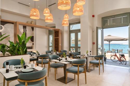 a restaurant with tables and chairs and a view of the ocean at YeeOn Living-Well Boutique City Hotel Gythio in Gythio