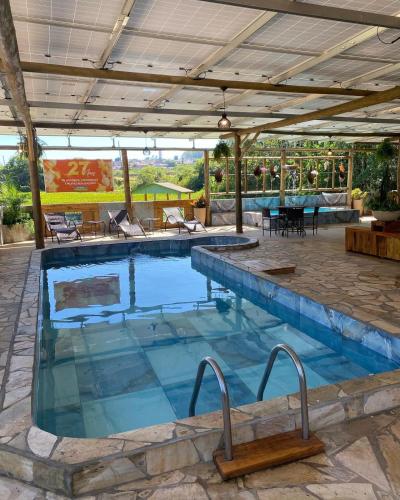 a large swimming pool with a table and chairs at Pousada Paraíso das Águas in Itirapina