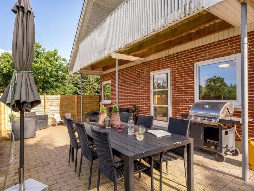 a patio with a table and chairs and a grill at Holiday Home Ditleif - 8km to the inlet by Interhome in Ringkøbing