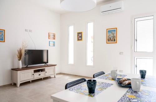 a living room with a table and a tv at A CASA DI CRISTINA in Lampedusa