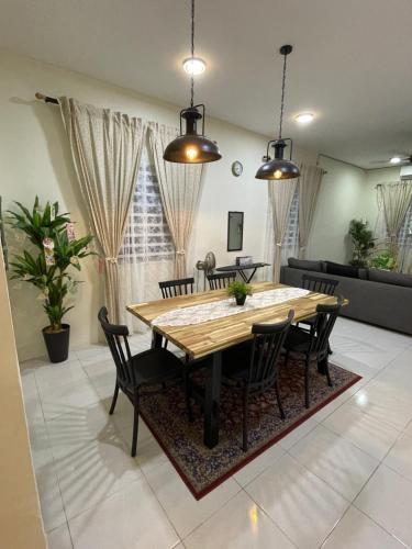 a dining room with a wooden table and chairs at Inang Homestay in Teluk Intan