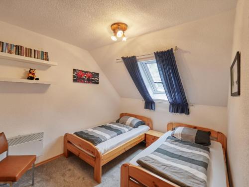 a bedroom with two beds and a window at Holiday Home Hänsel & Gretel im Kellerwald by Interhome in Frankenau