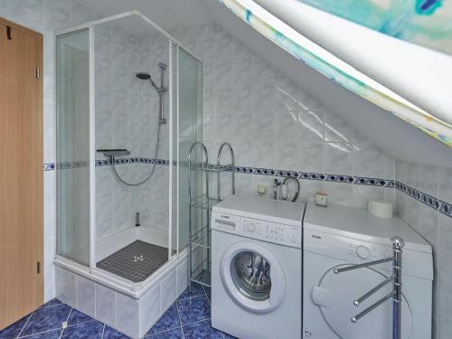 a bathroom with a washing machine and a shower at Holiday Home Hänsel & Gretel im Kellerwald by Interhome in Frankenau