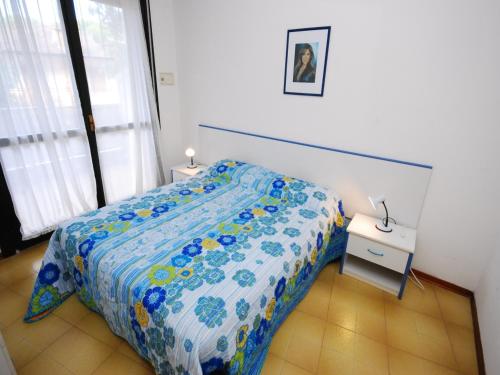 sypialnia z łóżkiem z niebiesko-białą kołdrą w obiekcie Residenza La Meridiana w Lignano Sabbiadoro