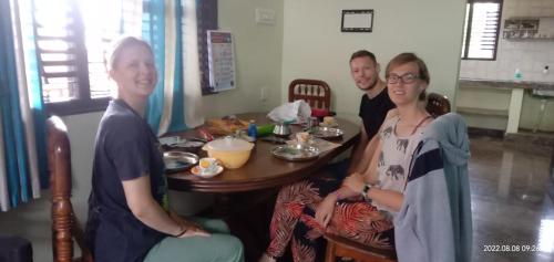 a group of three people sitting around a table at Sahana Villa in New Hampi