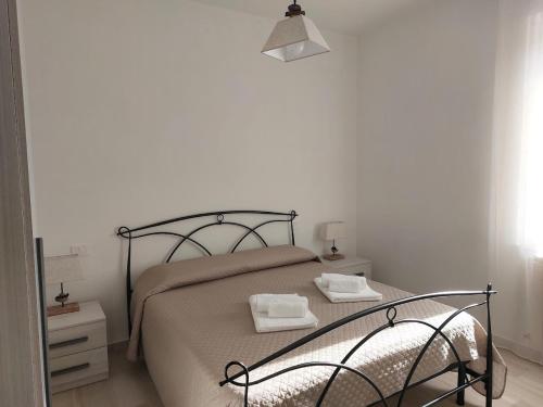 a bedroom with a bed with a black metal bed frame at A Casa di Enrichetta in Montalcino