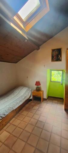a bedroom with a bed and a lamp on a table at Le gîte des Roussels in Rousses
