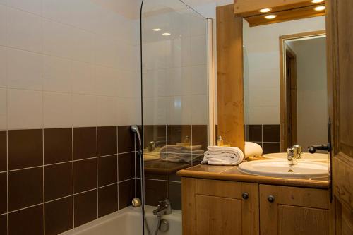 a bathroom with a tub and a sink and a shower at Résidence Goélia Les Chalets de Wengen in Les Coches