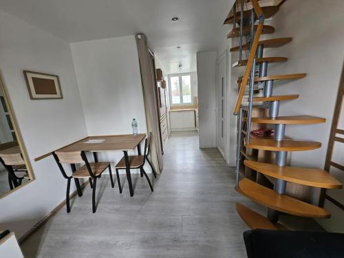 une pièce avec un escalier, une table et des chaises dans l'établissement Le Duplex Vercingétorix proche Paris et Disney, à Champigny-sur-Marne