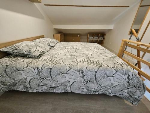 una camera da letto con un letto con un piumone di Le Duplex Vercingétorix proche Paris et Disney a Champigny-sur-Marne