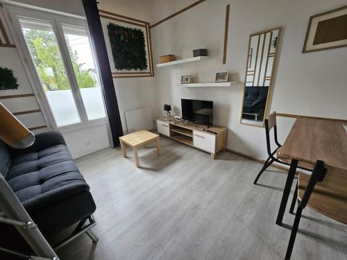 un soggiorno con un divano e una TV di Le Duplex Vercingétorix proche Paris et Disney a Champigny-sur-Marne