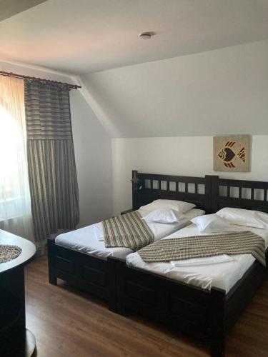 a bedroom with two beds and a window at Pensiunea EDEN in Crisan