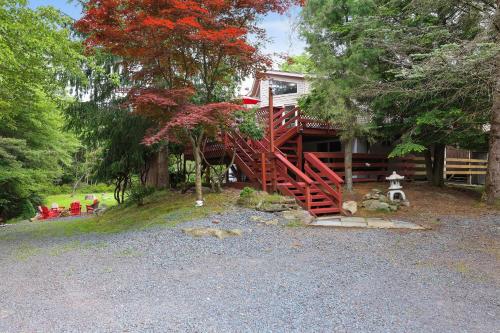 a house with a red stairway in front of it at Cozy cottage in the heart of pocono in Long Pond