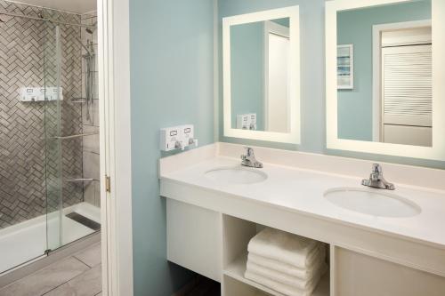 a bathroom with two sinks and a shower at Surfside Hotel and Suites in Provincetown