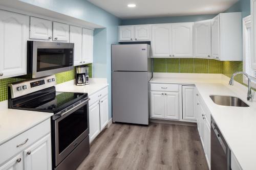a kitchen with white cabinets and a refrigerator at Surfside Hotel and Suites in Provincetown