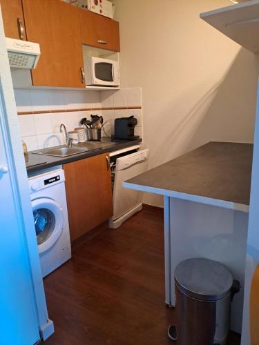 une petite cuisine avec un évier et une machine à laver dans l'établissement l été en montagne avec piscine 7 personnes, à Ax-les-Thermes