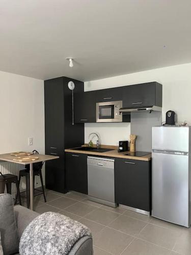 une cuisine avec un réfrigérateur blanc et une table dans l'établissement Appartement neuf T2 Livry-Gargan, à Livry-Gargan