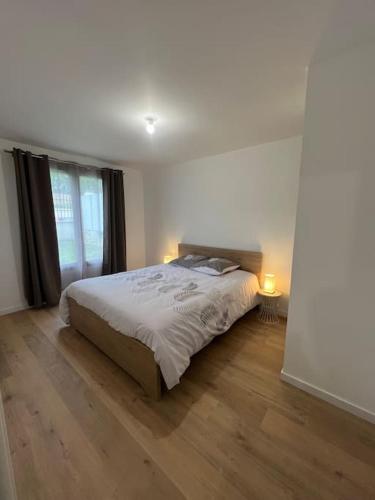- une chambre avec un lit et deux lampes sur du parquet dans l'établissement Appartement neuf T2 Livry-Gargan, à Livry-Gargan