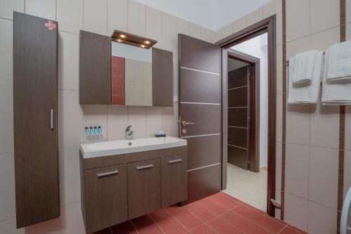 a bathroom with a sink and a mirror at Starfish House - Close to the Beach in Goúdhouros