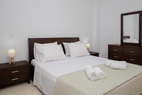 a bedroom with two beds with white sheets and towels at Starfish House - Close to the Beach in Goúdhouros