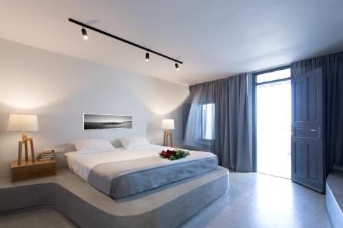 a bedroom with a large bed and a large window at Xenones Filotera in Imerovigli