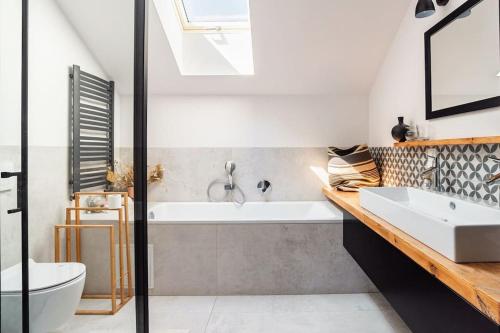 a bathroom with a white tub and a sink at Parkowa Garden in Michałowice