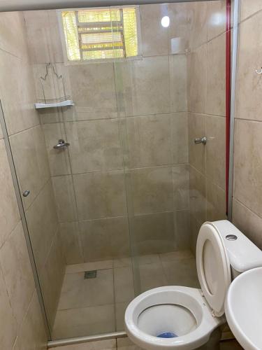 a bathroom with a shower with a toilet and a sink at Pousada Paraíso das Águas in Itirapina