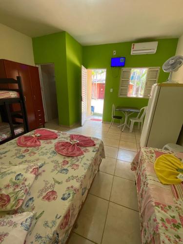 two beds in a room with green walls at Pousada Paraíso das Águas in Itirapina